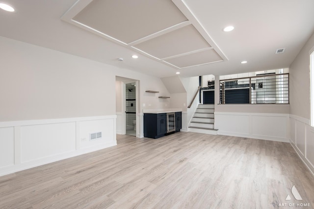 unfurnished living room featuring light hardwood / wood-style flooring and wine cooler