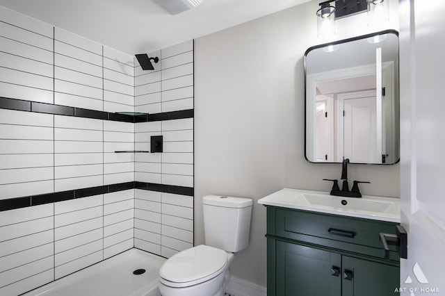 bathroom featuring vanity, toilet, and tiled shower