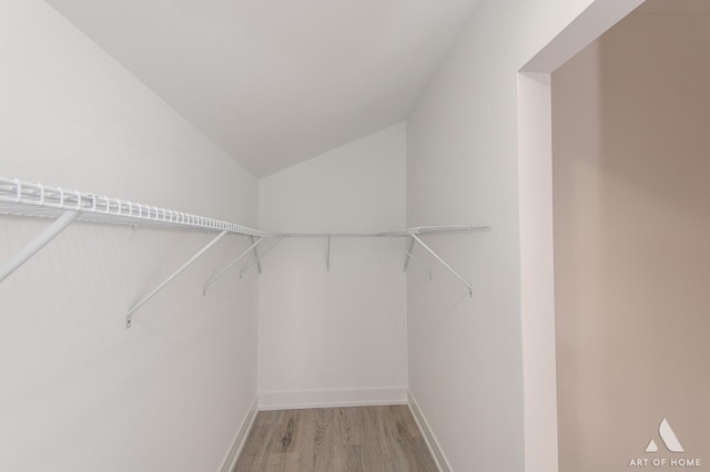 walk in closet featuring light wood-type flooring and lofted ceiling