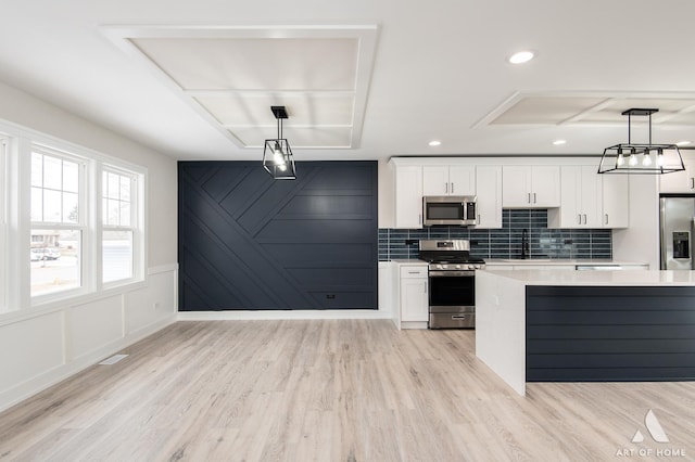 kitchen featuring white cabinets, pendant lighting, and appliances with stainless steel finishes