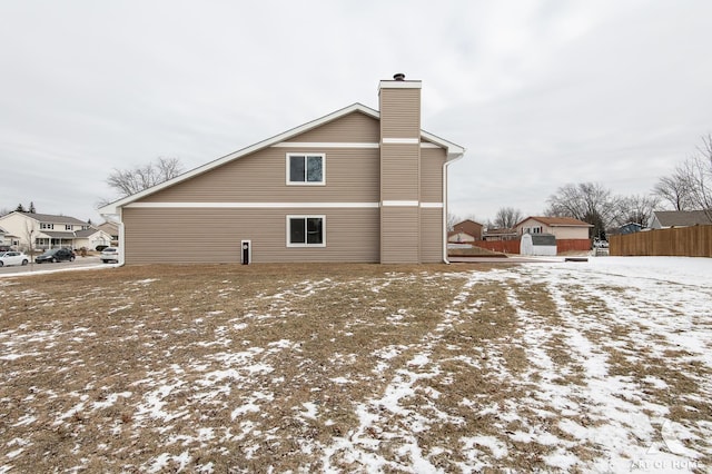 view of snow covered back of property