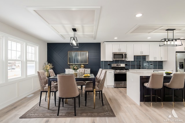 dining area with sink and light hardwood / wood-style floors