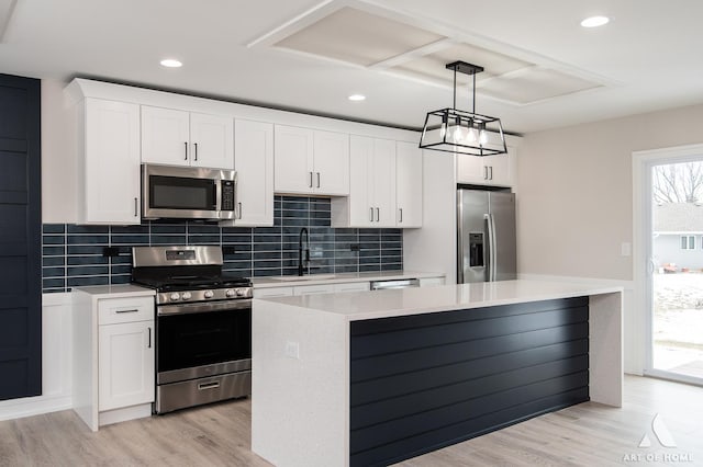 kitchen with sink, a kitchen island, white cabinetry, and stainless steel appliances