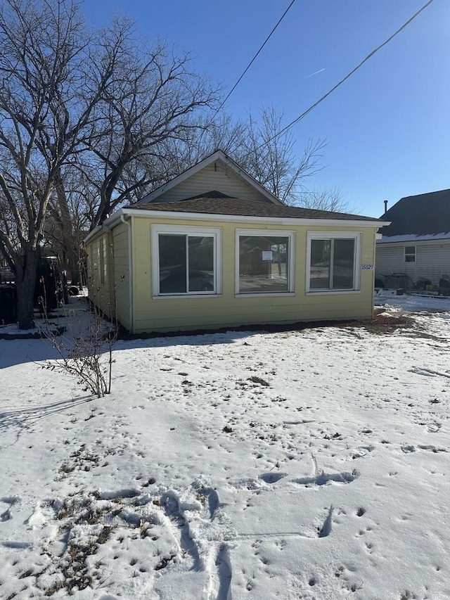 view of snow covered rear of property