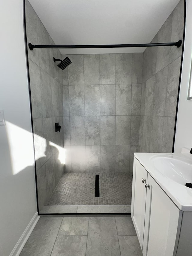 bathroom with vanity, tile patterned floors, and a tile shower