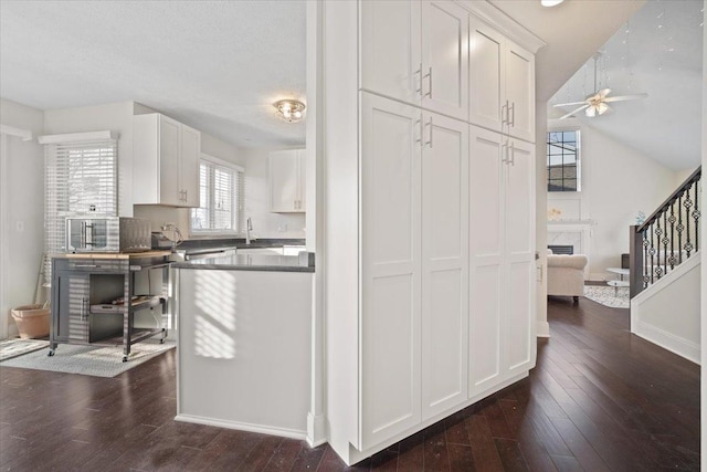 kitchen with sink, dark hardwood / wood-style floors, white cabinets, and ceiling fan