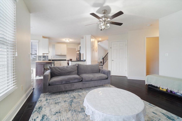 living room featuring dark hardwood / wood-style flooring and ceiling fan