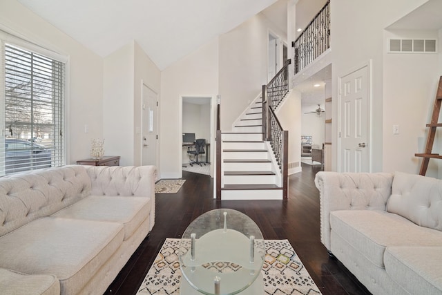 living room featuring dark wood-type flooring and high vaulted ceiling