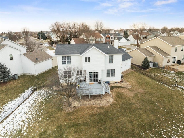 snow covered house with a wooden deck and a lawn