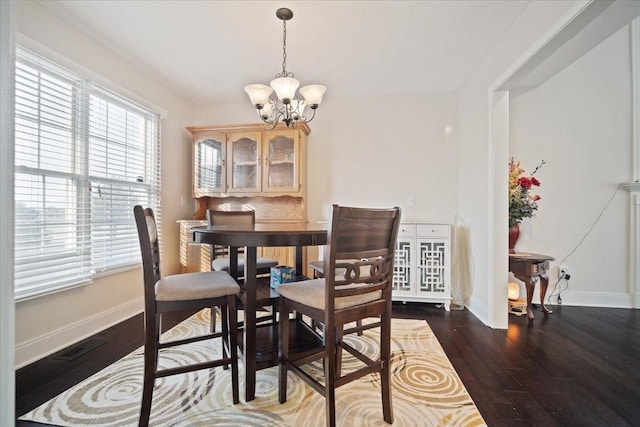 dining room featuring a notable chandelier and dark hardwood / wood-style flooring