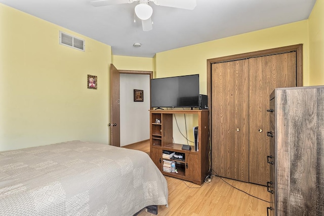 bedroom with ceiling fan, a closet, and light hardwood / wood-style flooring