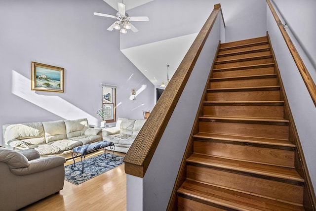 staircase with ceiling fan and wood-type flooring