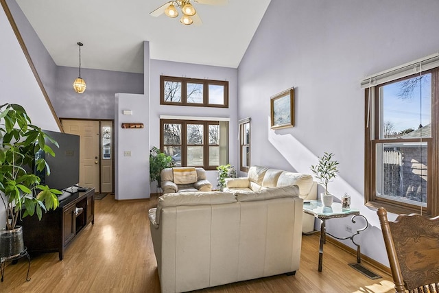 living room featuring ceiling fan, a wealth of natural light, high vaulted ceiling, and light hardwood / wood-style flooring