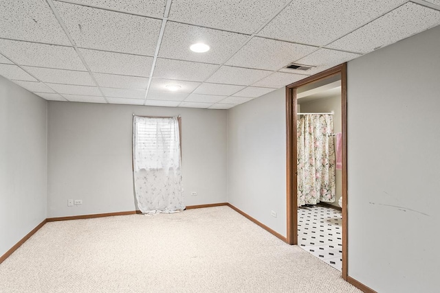 carpeted empty room with a paneled ceiling