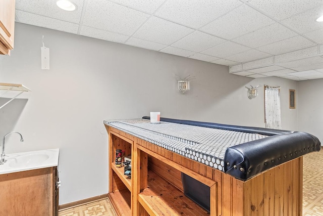 interior space featuring a drop ceiling and sink