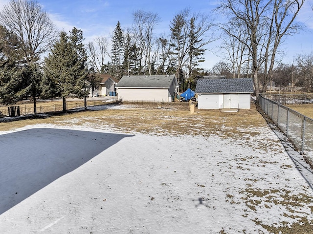 yard covered in snow featuring a storage shed