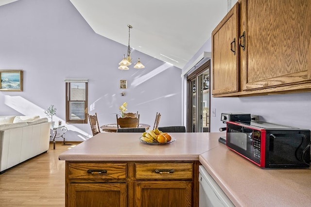 kitchen featuring an inviting chandelier, white dishwasher, decorative light fixtures, vaulted ceiling, and light wood-type flooring