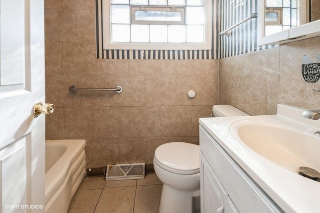 bathroom with toilet, a tub to relax in, tile patterned flooring, and a wealth of natural light