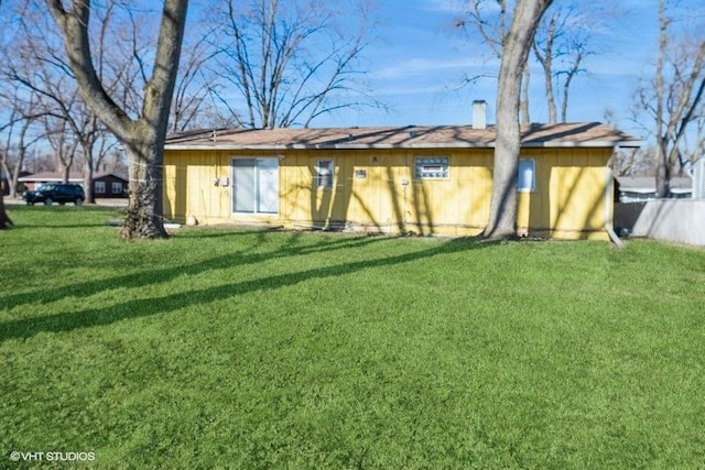 rear view of house featuring a yard