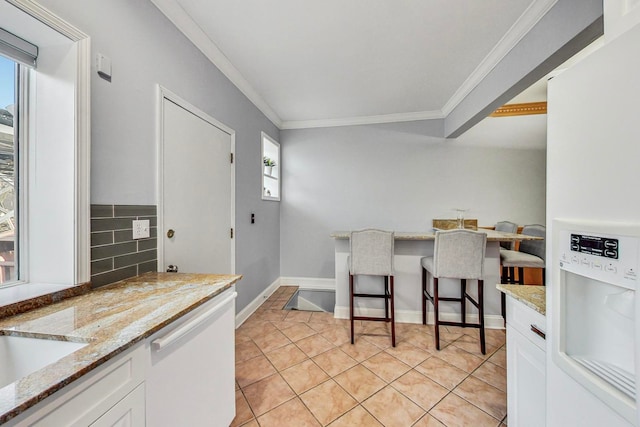 4332 N Kenmore Ave, Chicago, IL 60613 - kitchen with light tile patterned flooring, white cabinets, ornamental molding, light stone countertops, and white appliances