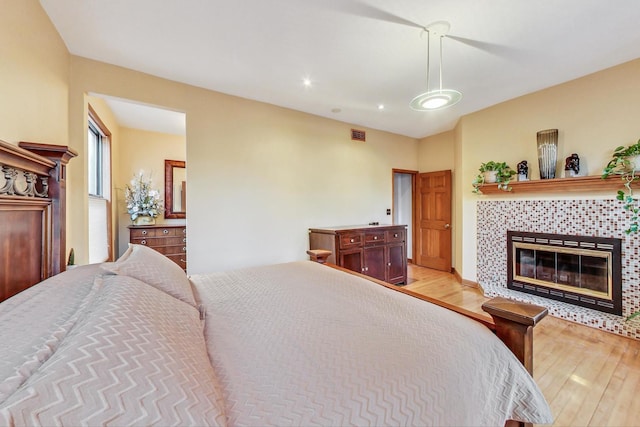 4332 N Kenmore Ave, Chicago, IL 60613 - bedroom featuring a tile fireplace and light hardwood / wood-style flooring