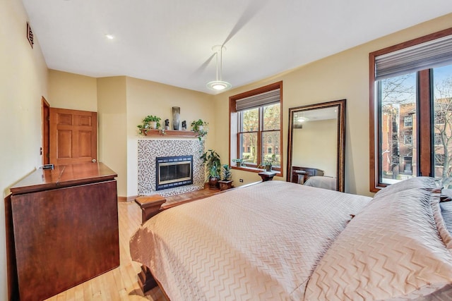 4332 N Kenmore Ave, Chicago, IL 60613 - bedroom with a tiled fireplace and light hardwood / wood-style flooring