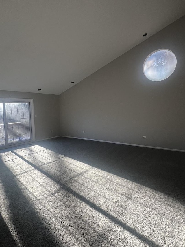 empty room featuring lofted ceiling and carpet flooring