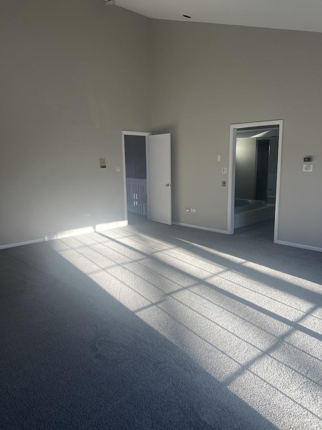 spare room with a towering ceiling and carpet flooring