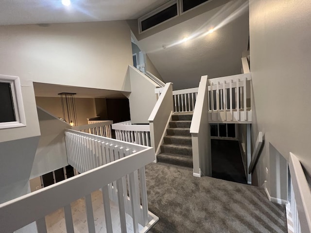 stairs with lofted ceiling and carpet flooring