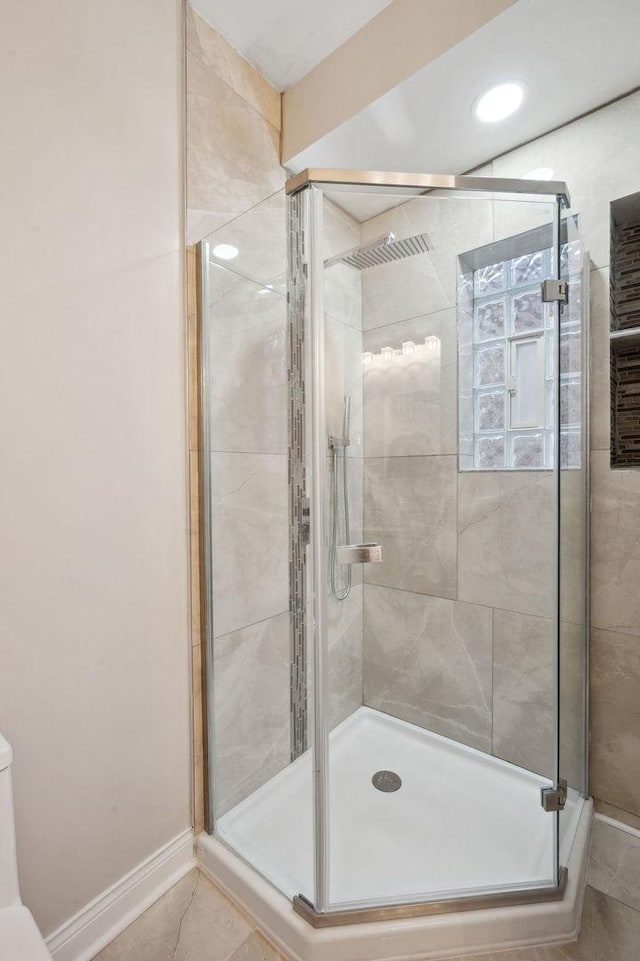 bathroom with a shower with door and tile patterned floors