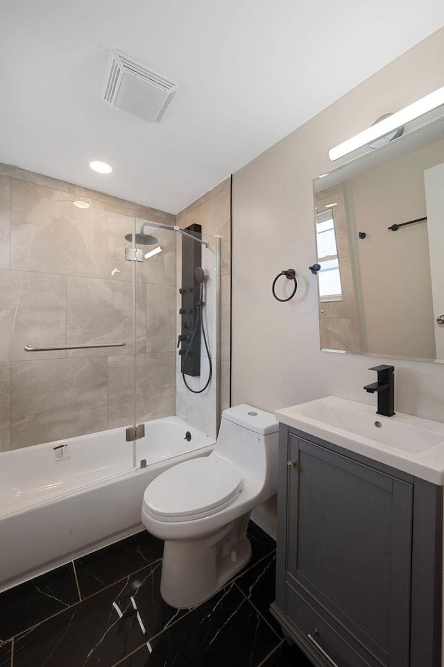 full bathroom with tiled shower / bath combo, toilet, and vanity