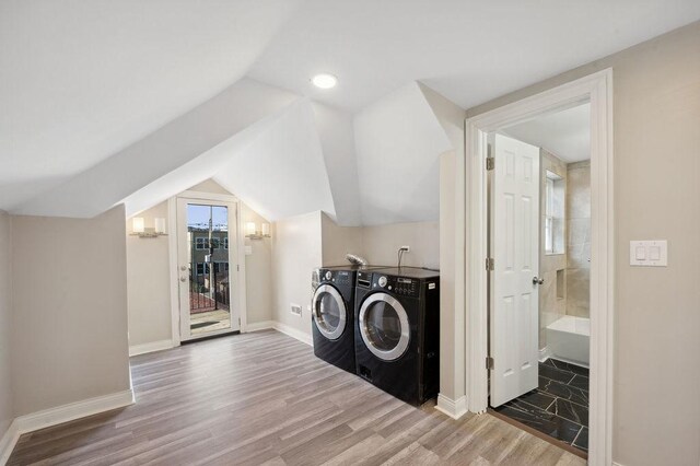 laundry area with wood-type flooring and washing machine and clothes dryer