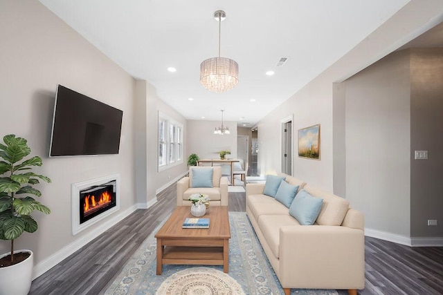 living room featuring an inviting chandelier and dark wood-type flooring