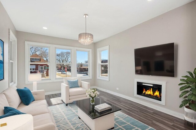 living room with dark wood-type flooring and a notable chandelier