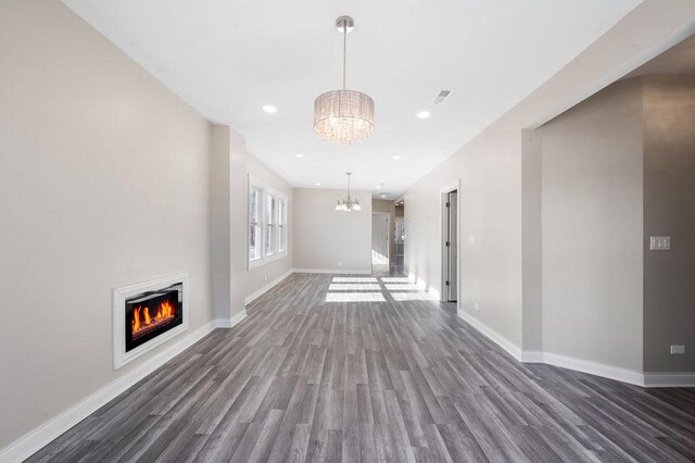 unfurnished living room featuring dark hardwood / wood-style floors and a notable chandelier