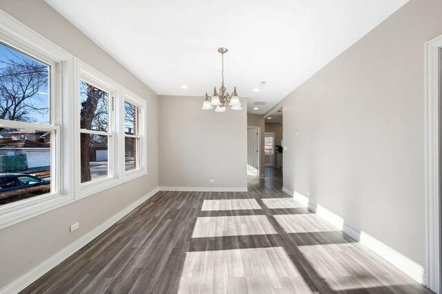 unfurnished dining area with hardwood / wood-style floors and a chandelier