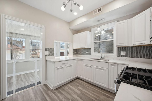 kitchen with sink, decorative light fixtures, white cabinets, and decorative backsplash