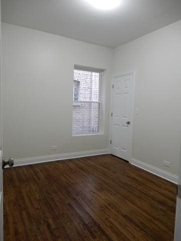 empty room with dark hardwood / wood-style flooring