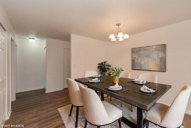 dining room with dark hardwood / wood-style floors and a notable chandelier