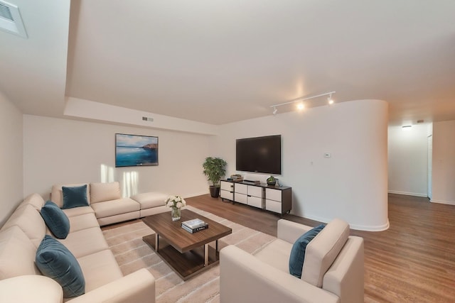 living room with rail lighting and light wood-type flooring