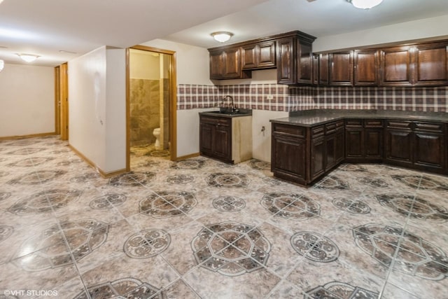 kitchen with decorative backsplash, sink, and dark brown cabinetry