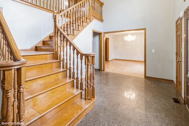 staircase featuring a high ceiling and a chandelier