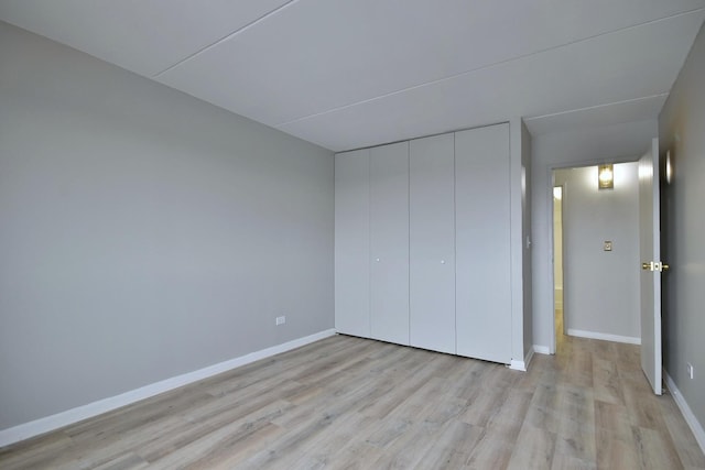 unfurnished bedroom featuring light hardwood / wood-style floors and a closet