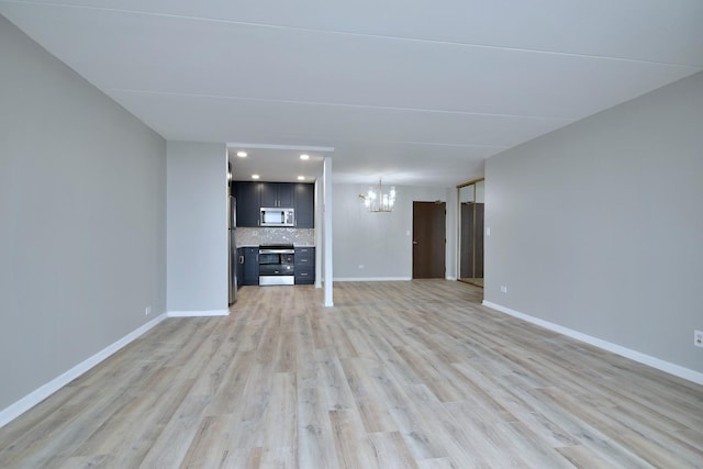 unfurnished living room featuring light hardwood / wood-style flooring and an inviting chandelier