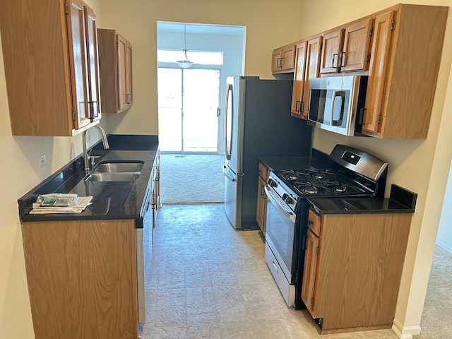 kitchen with sink, light colored carpet, and appliances with stainless steel finishes