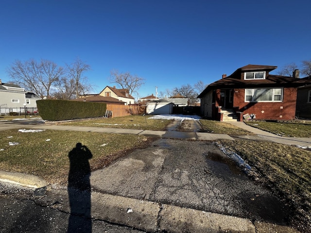 view of front facade with a garage, an outdoor structure, and a front lawn