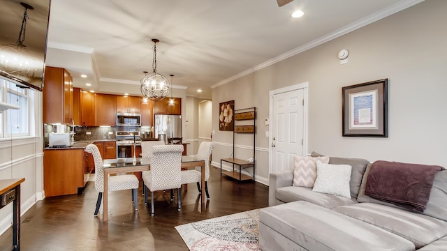 living room featuring a chandelier, ornamental molding, and dark hardwood / wood-style floors