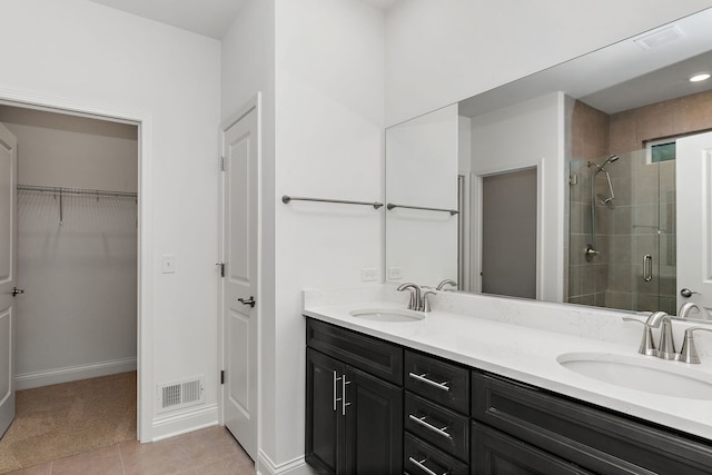 bathroom with walk in shower, vanity, and tile patterned flooring