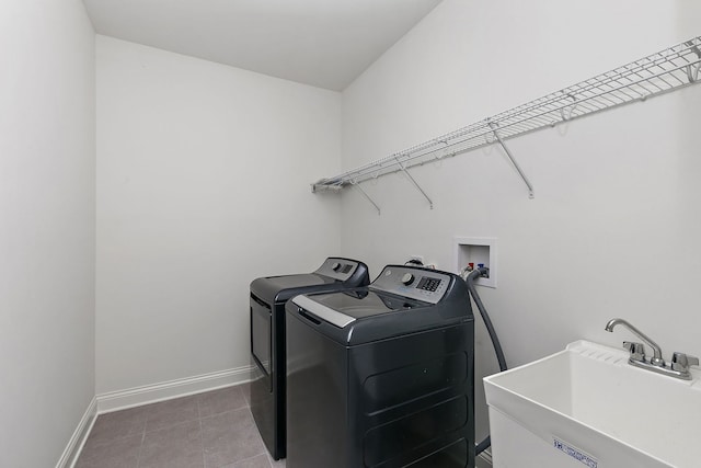 washroom featuring sink, washing machine and clothes dryer, and tile patterned flooring