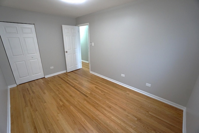 unfurnished bedroom featuring a closet and light hardwood / wood-style floors